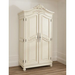 An ornate shabby chic white armoire in a room.