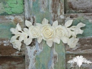 White roses adorning a shabby chic wooden door.