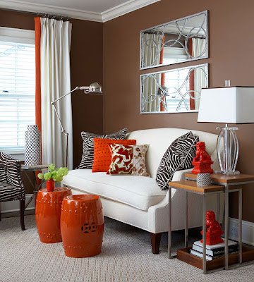A living room with orange accents and white furniture introduces garden stools.