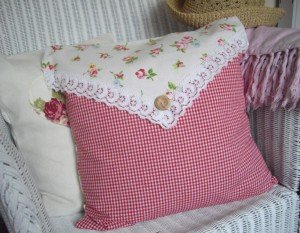 A shabby chic pillow on a wicker chair.