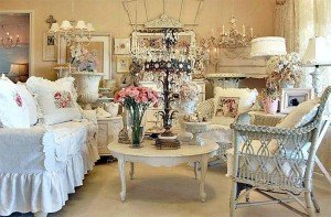 A shabby chic living room featuring white furniture and flowers.
