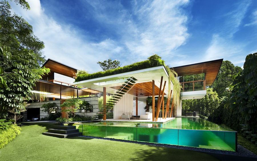 A modern house with a green roofing system and a swimming pool in the middle.