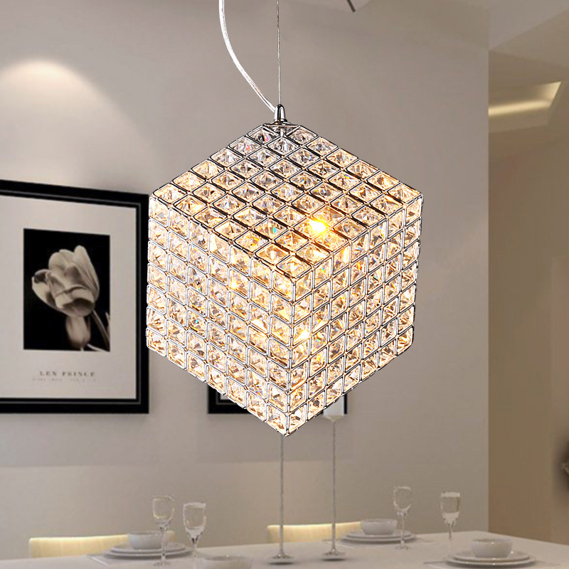 A modern dining room with a shimmering crystal pendant light.
