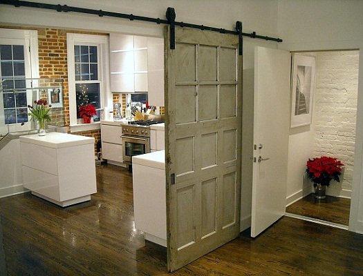 A kitchen with a sliding barn door for interior spaces.