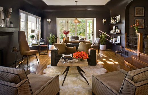 A cozy living space with black walls and brown furniture.
