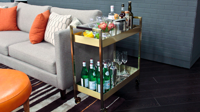 Keywords: Functional, Entertaining Space

Modified Description: A functional gold bar cart in a living room, creating an entertaining space.