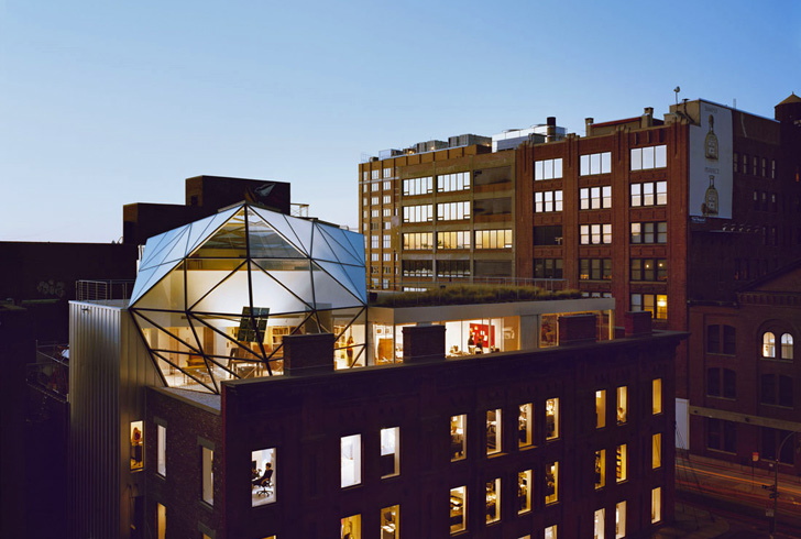 A building with a glass dome and a green roofing system on top of it.