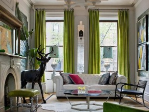 A living room with bold green curtains and a deer.