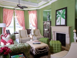 A living room with vibrant green walls and zebra print furniture.