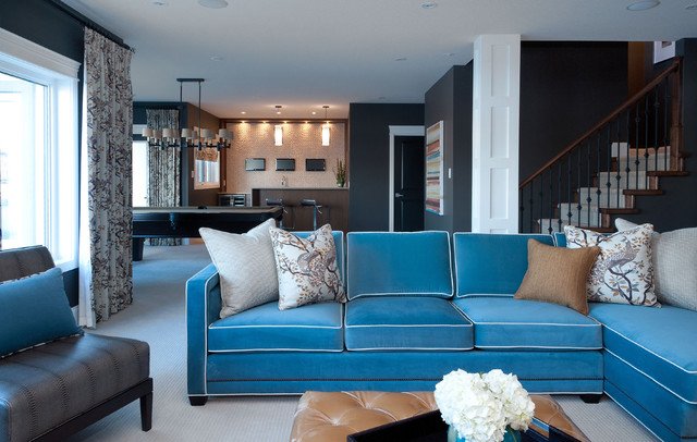 A living room with a blue velvet couch and coffee table.