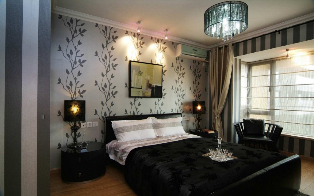 A romantic bedroom with black and white wallpaper and a chandelier.