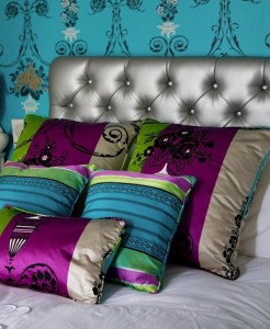 A bed with bold-colored pillows.