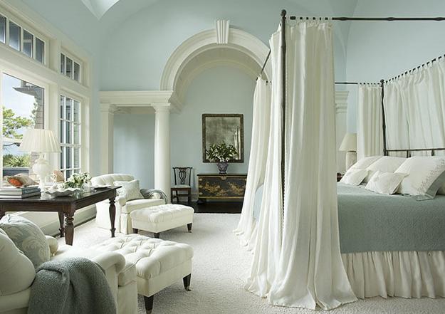 Creating a romantic bedroom with a white four poster bed and blue walls.