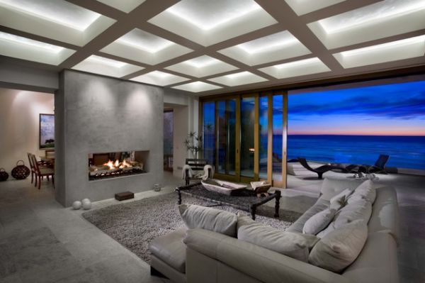 A living room with a view of the ocean and fireplace.