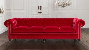Red velvet sofa in a white room.