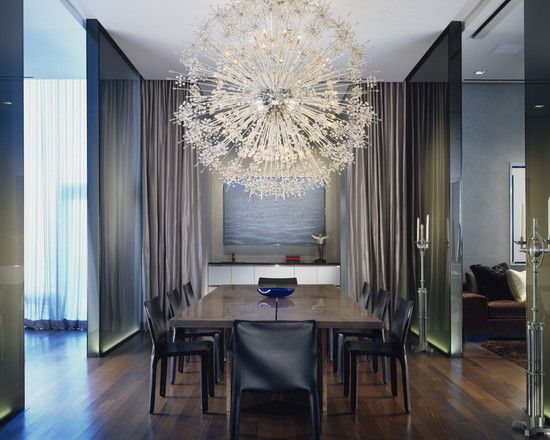 A modern dining room with a shimmering chandelier.