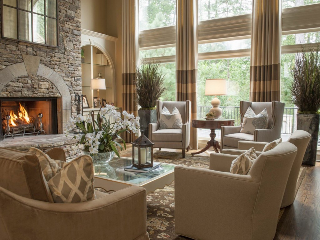 A living room with large windows and a stone fireplace, creating a cozy space.
