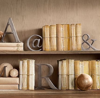 A shelf adorned with books and metal letters for creative decorating.