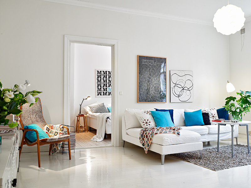 A white living room with blue accents inspired by Scandinavian design.