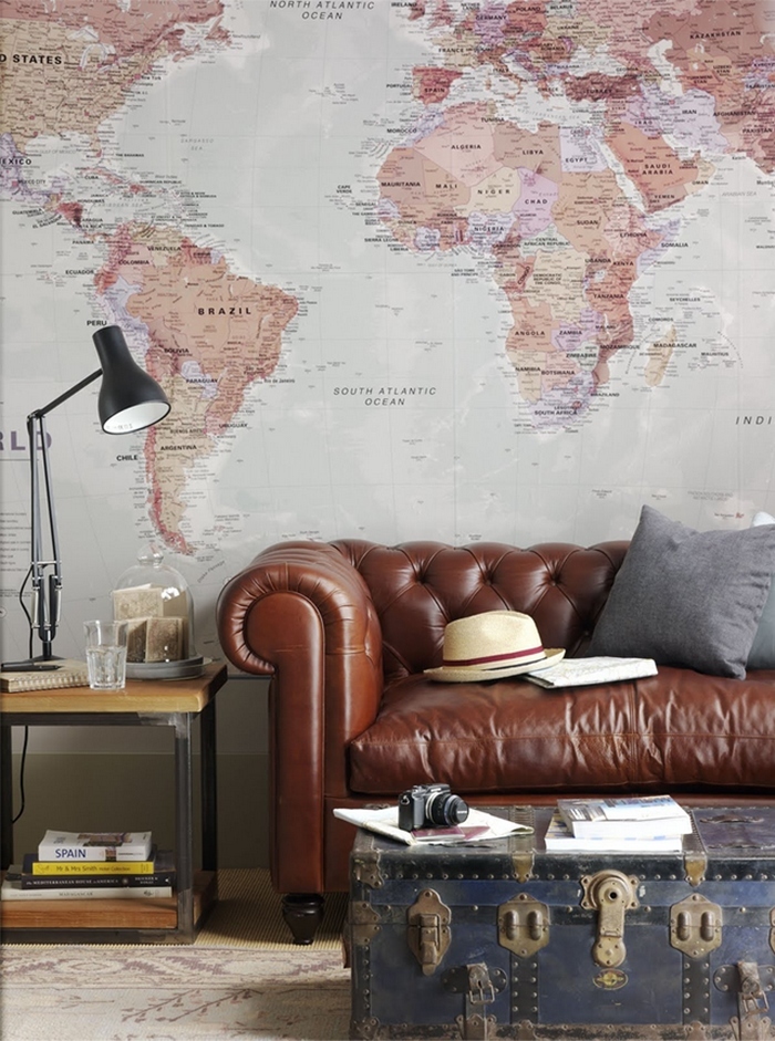 A steampunk-inspired living room with leather furniture and a world map on the wall.