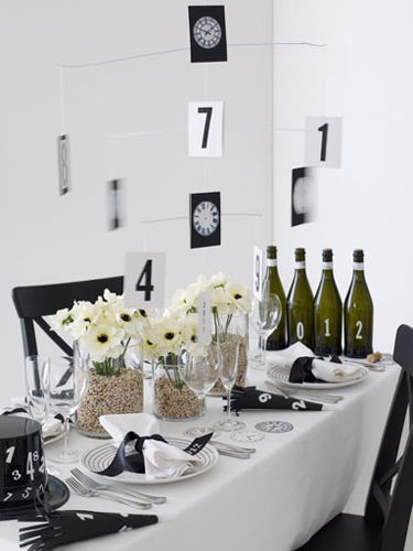 A black and white table setting with a bottle of wine, perfect for a stylish New Year's Eve party decoration.