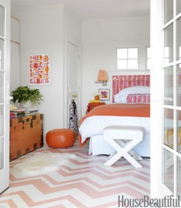 An orange and white bedroom with chevron flooring, incorporating top bedroom colors of 2015.