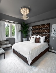 A bedroom with a large bed and a chandelier featuring top bedroom colors of 2015.