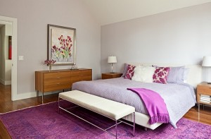 A purple and white bedroom suitable for the top bedroom colors of 2015, with hardwood floors.