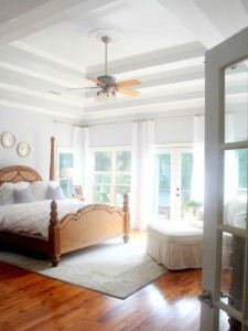 A bedroom with hardwood floors and a ceiling fan showcasing the top bedroom colors of 2015.