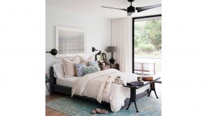 A bedroom with a bed and a fan decorated in the top bedroom colors of 2015.