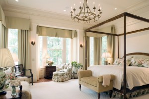 A bedroom with a four poster bed and a chandelier featuring top bedroom colors of 2015.