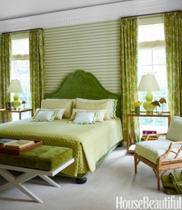 A bedroom with trendy green walls and accents.