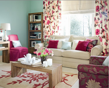 A living room with pink and blue walls featuring floral accents.
