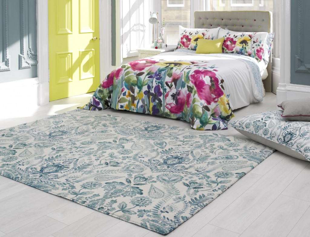 A bedroom with a colorful floral rug on the floor that incorporates interior design trends for 2015.