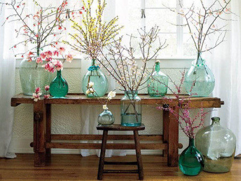 A table with several vases filled with flower arrangements.
