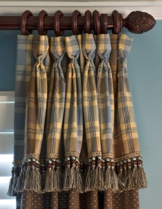 A plaid curtain with tassels showcasing texture.