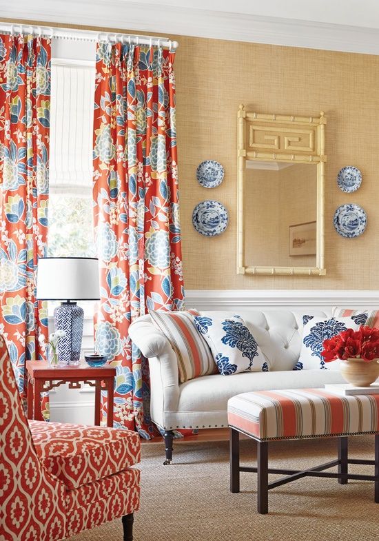 A living room with red and blue floral curtains.
