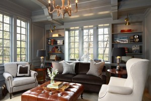 A living room with gray couches and a chandelier.