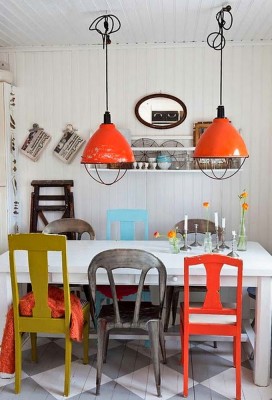 A colorful dining room with white chairs.