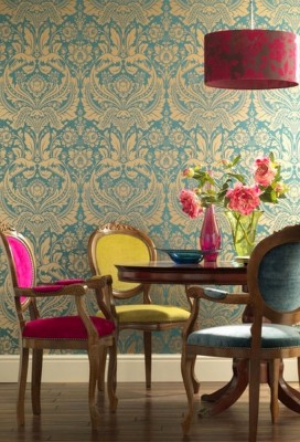 A colorful dining room with damask wallpaper.