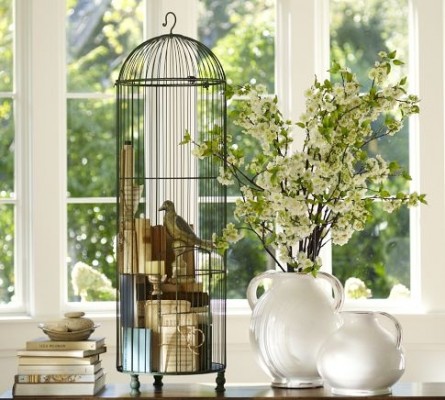 A vintage birdcage complements a table adorned with flowers.