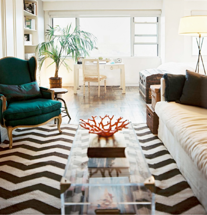 A trendy living room with a black and white chevron rug.