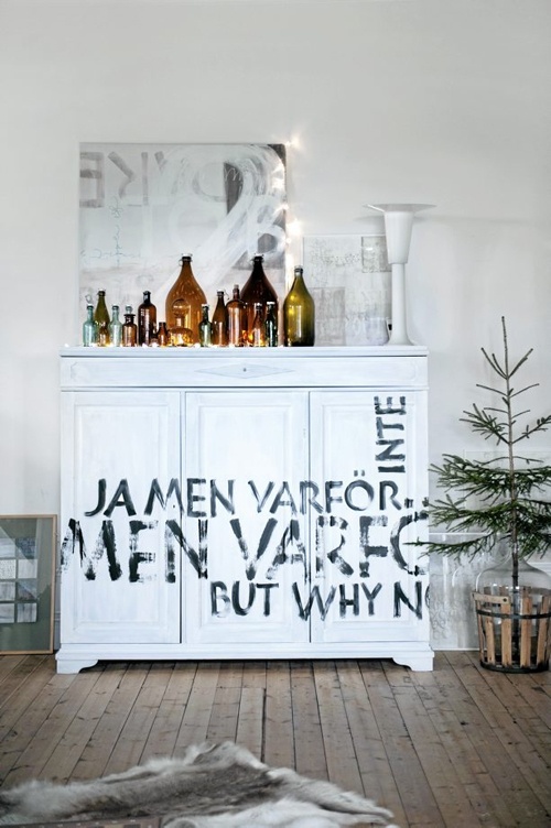 A trendy white dresser with a quote written on it.
