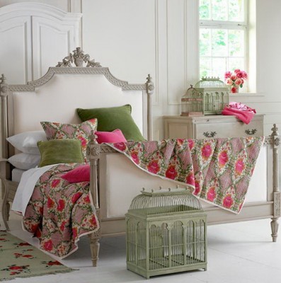 A vintage-inspired bedroom with a pink and green color scheme, featuring a bed adorned with a birdcage.