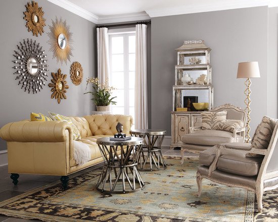 A living room with a yellow couch and gold accents, featuring a mix of metals.