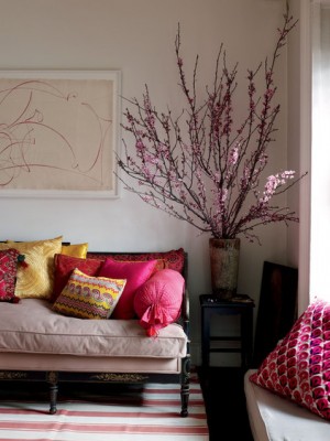 A couch with flower arrangements in a living room.