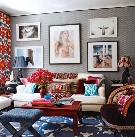 A living room with a colorful rug and framed pictures featuring global chic elements.