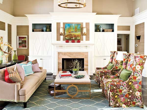 A living room with colorful floral furniture and a fireplace.