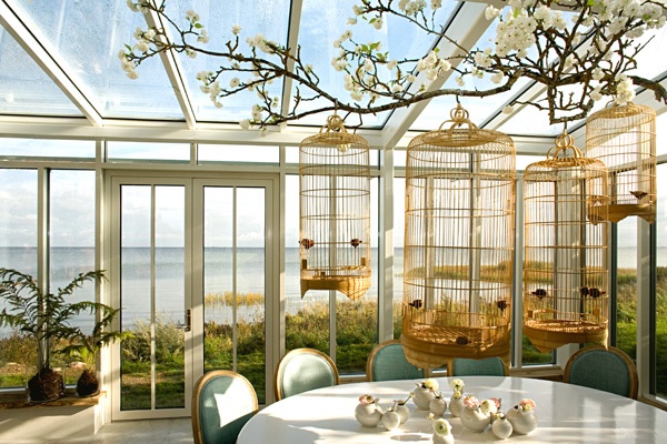 A dining room decorated with vintage bird cages.