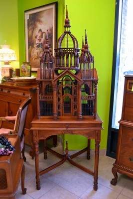 A vintage wooden birdcage as a decorative centerpiece on a table.